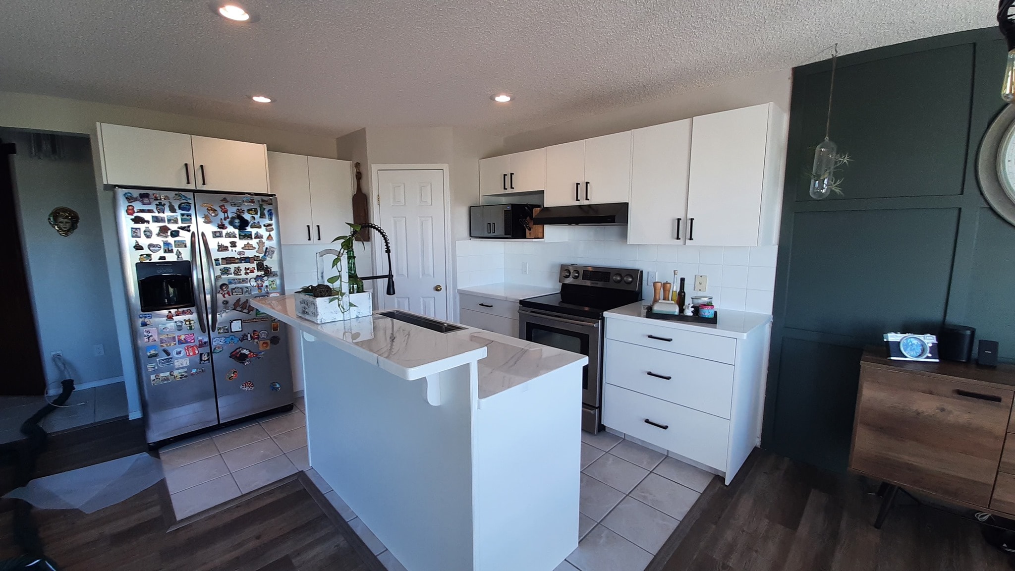 White kitchen cabinet painting with black hardware Calgary