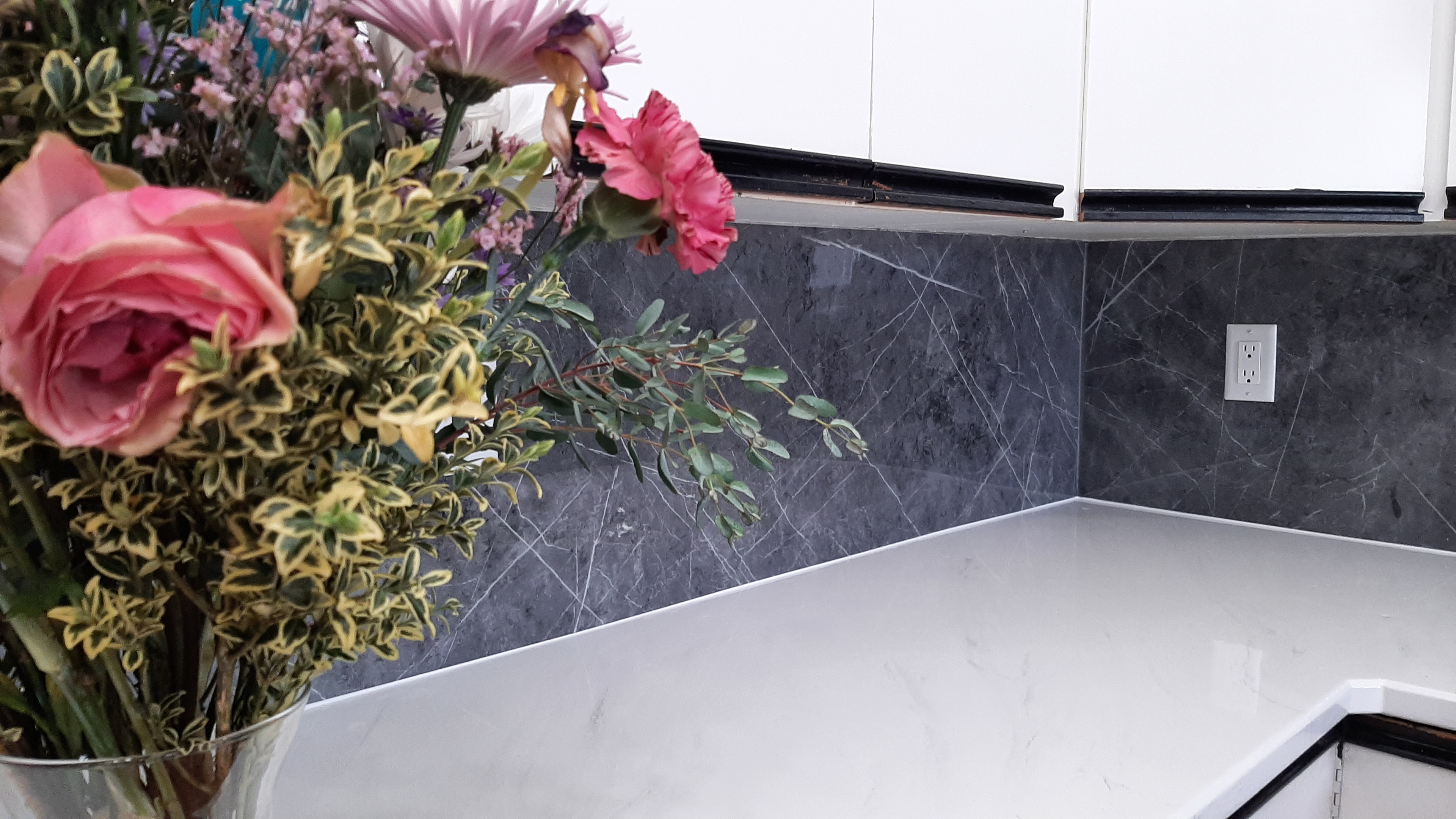 White countertop with dark marble-look backsplash Calgary